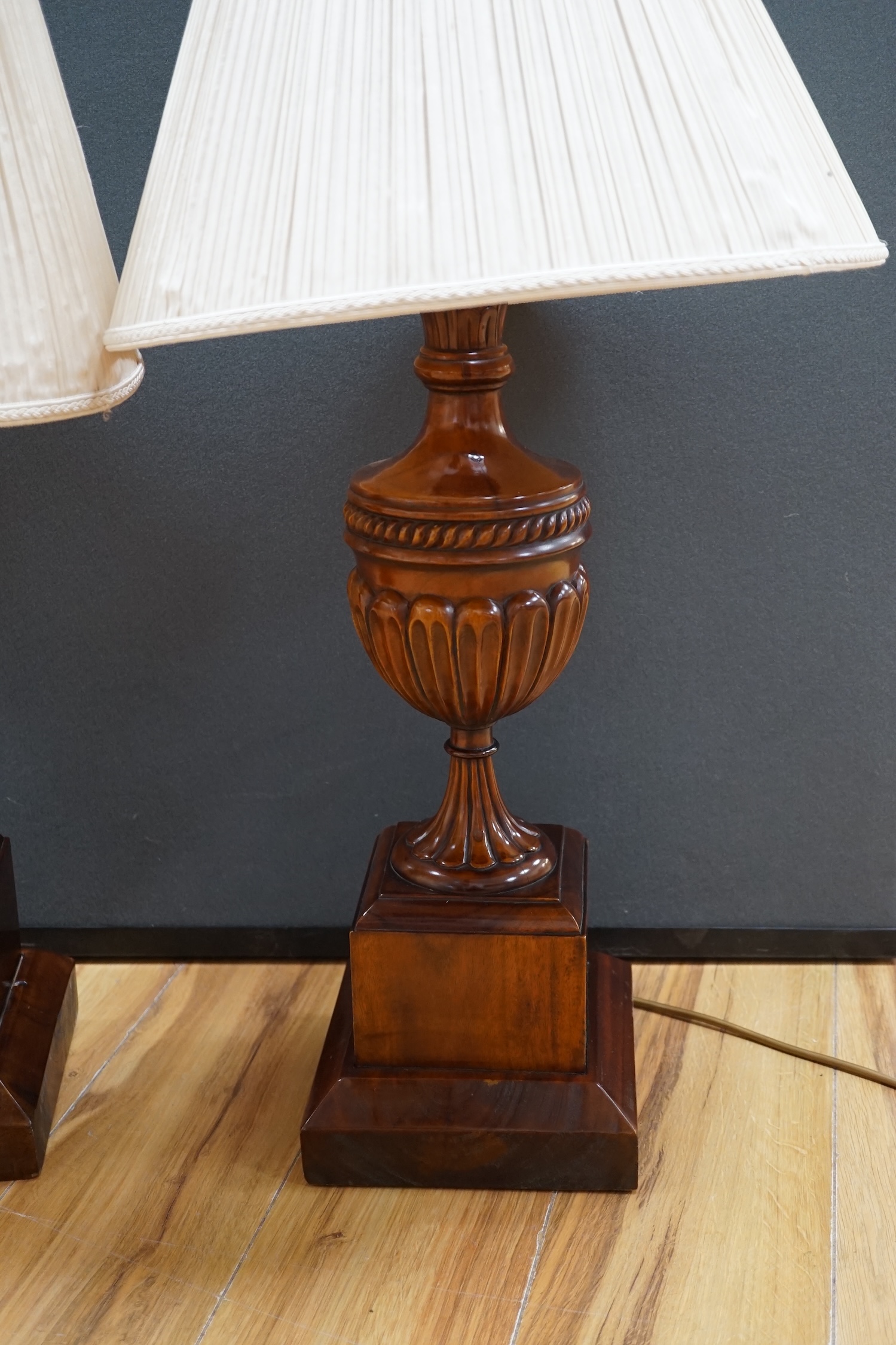 A pair of George III style mahogany carved urn table lamps with shades, 74cm high overall